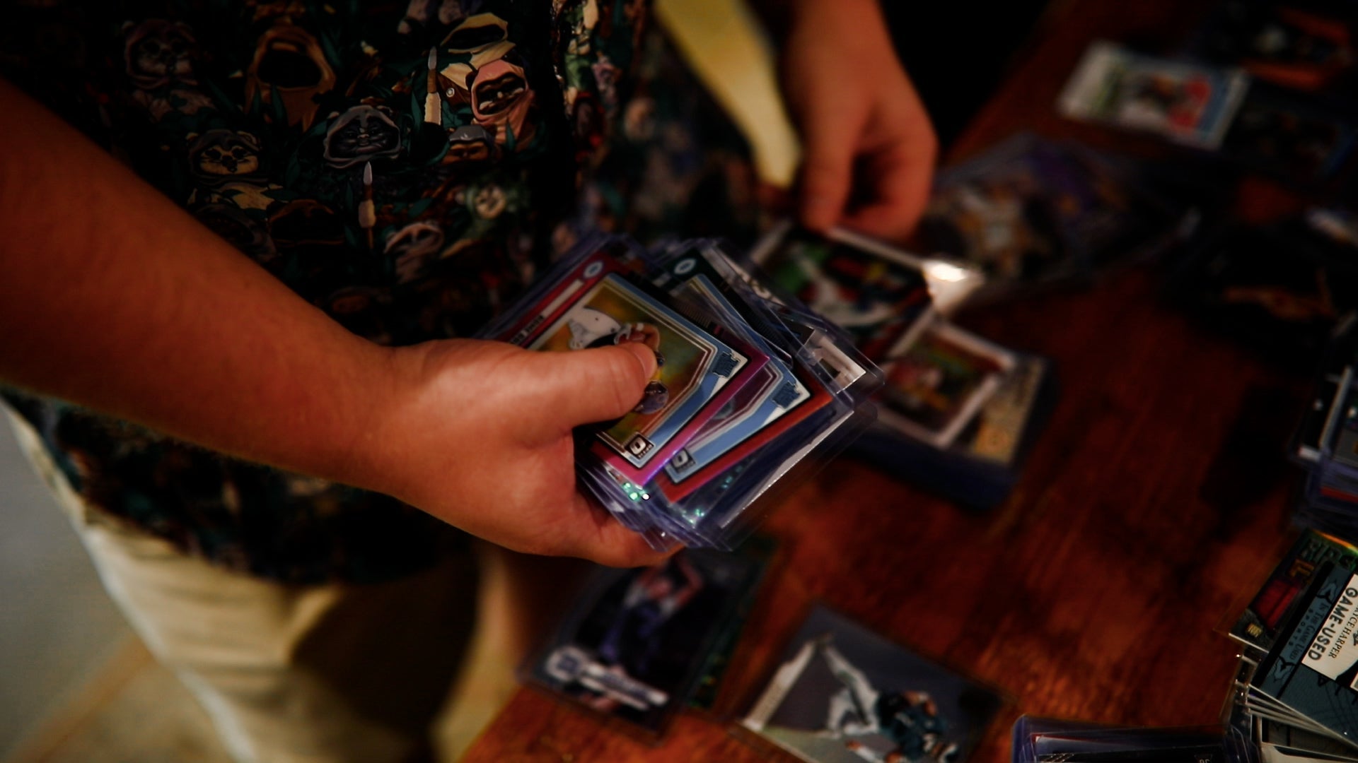 Person holding a deck of cards with a focus on card collection.