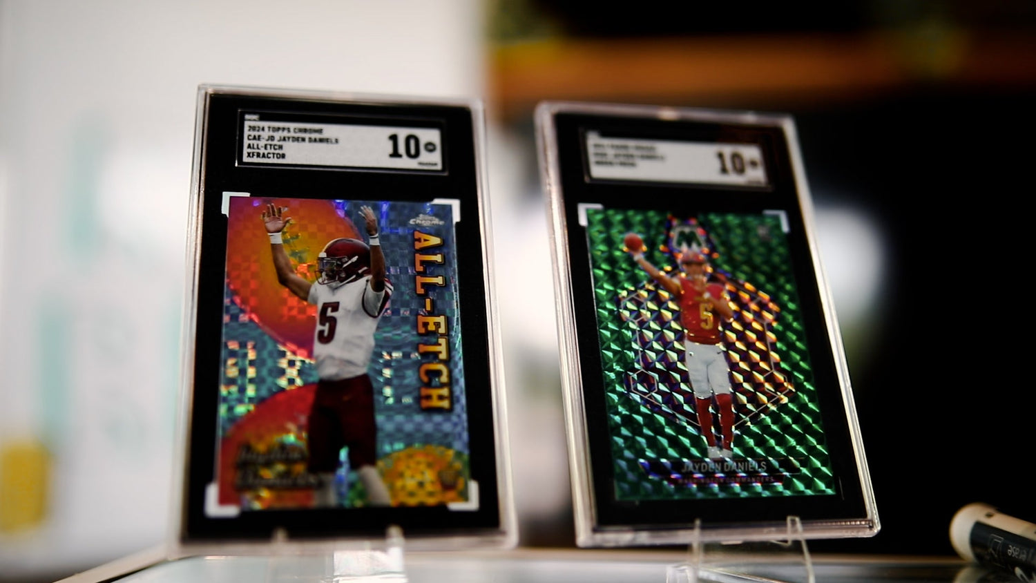 Two trading cards of a football player in display cases with grading labels.